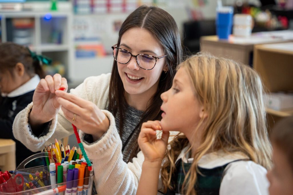 teacher helping student with a craft